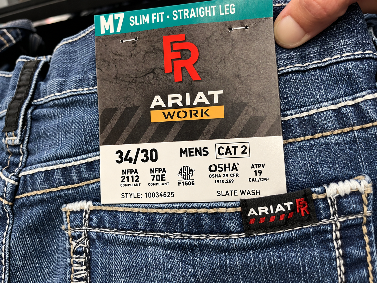 Ariat FR M7 jeans hangtag showing CAT 2, ATPV arc rating of 19 cal/cm&sup2;, and flame-resistant safety standards