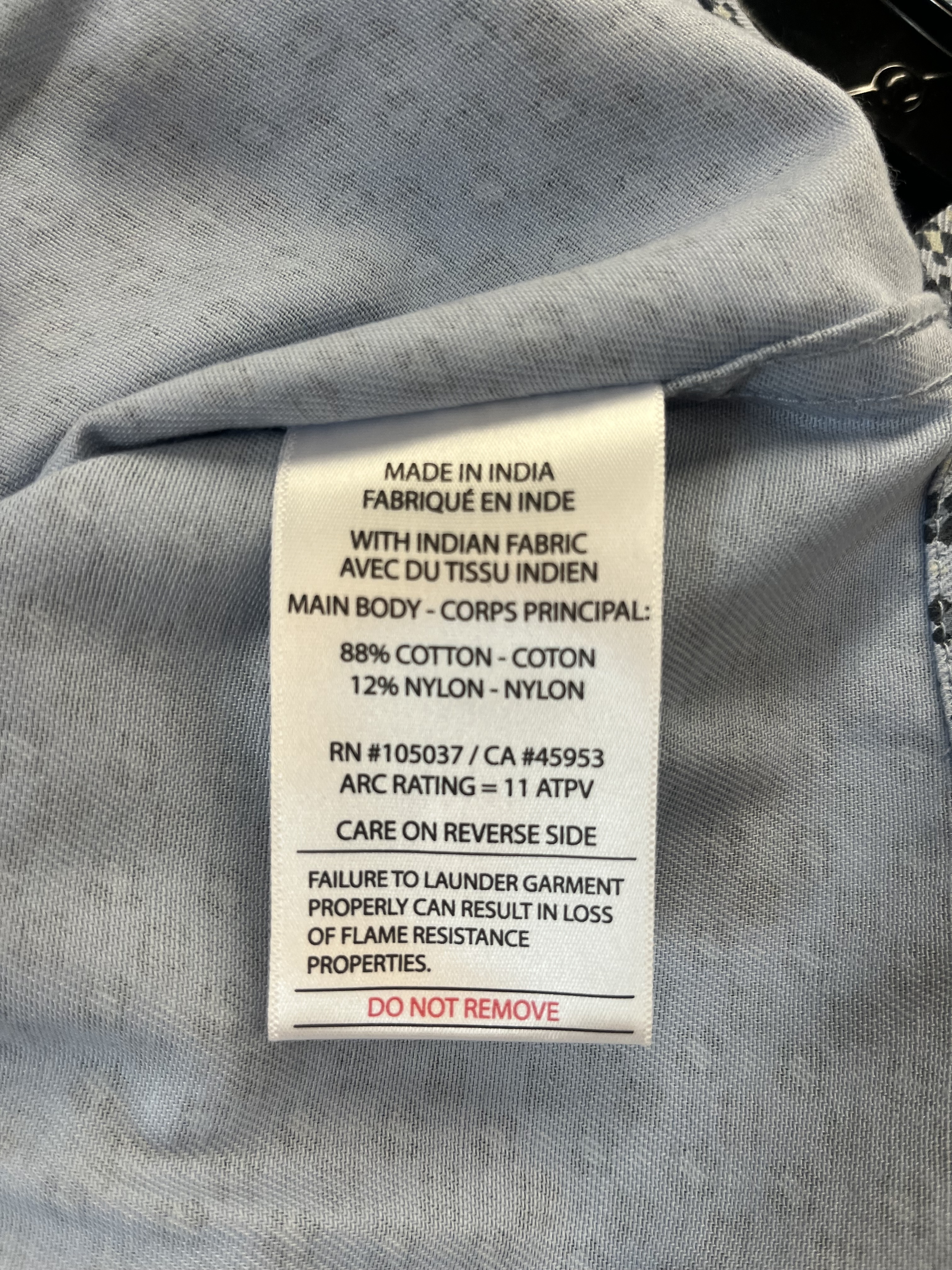 Sewn-in Ariat FR shirt label showing 11 ATPV arc rating, 88% cotton and 12% nylon fabric content.