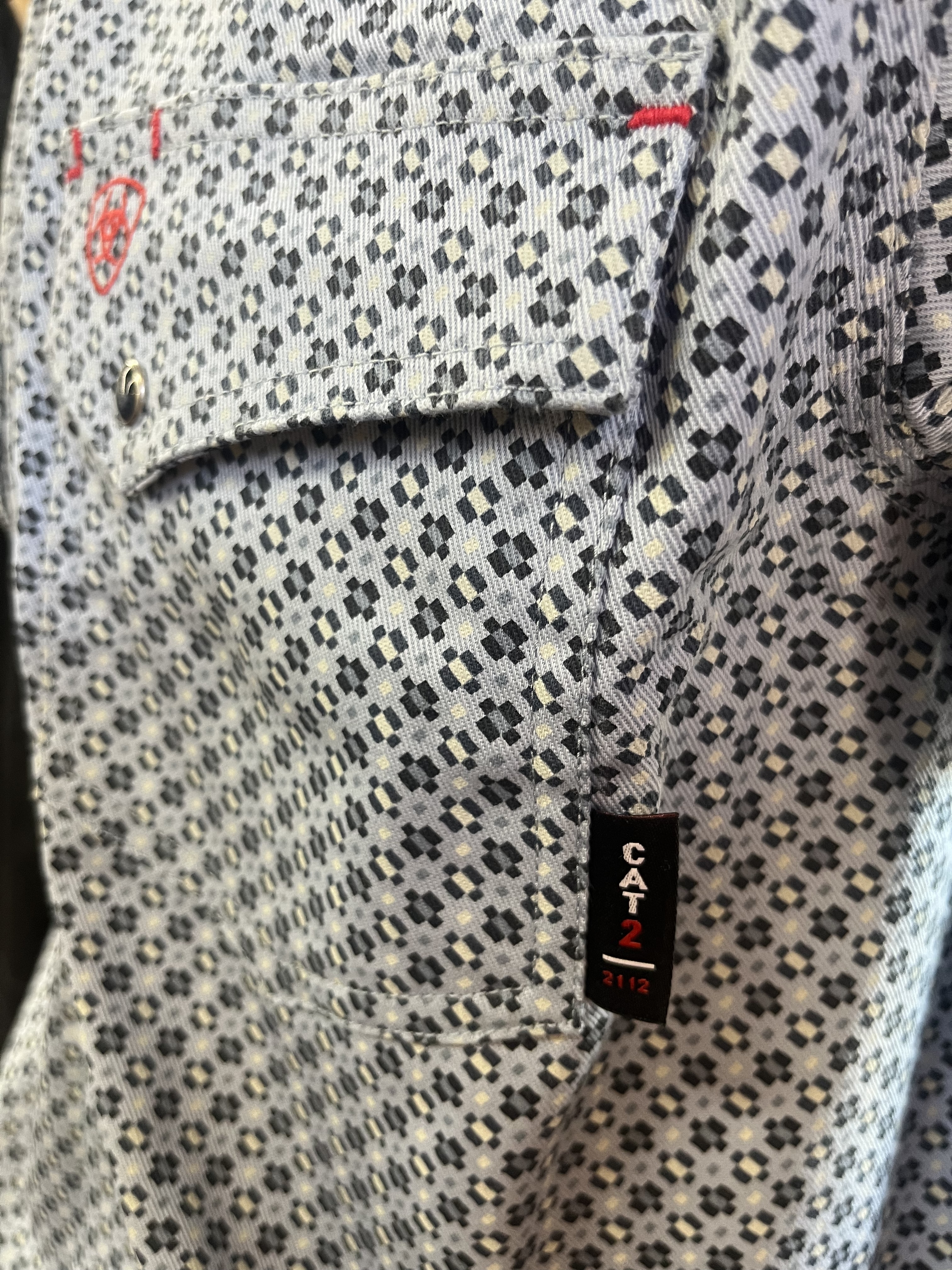 Ariat flame-resistant work shirt with sewn-on CAT 2 label indicating its arc-flash PPE category